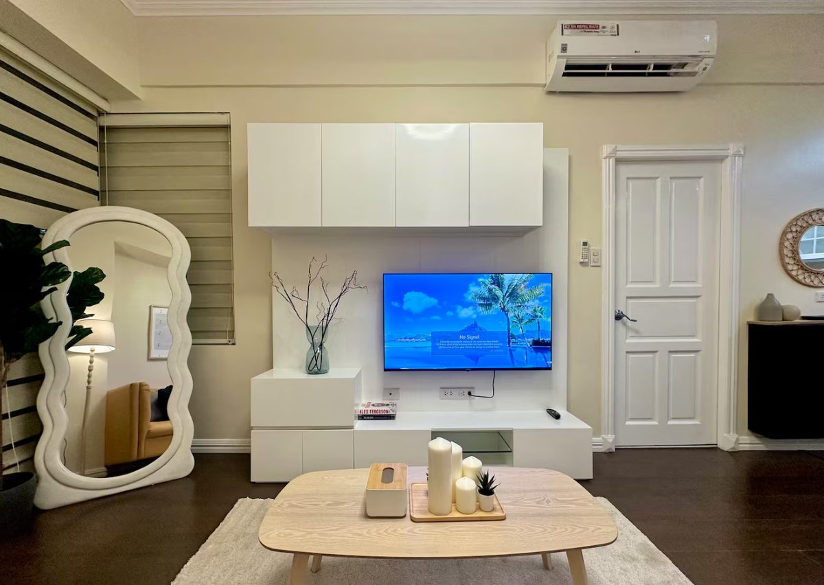 Condo living room with TV and full-length mirror